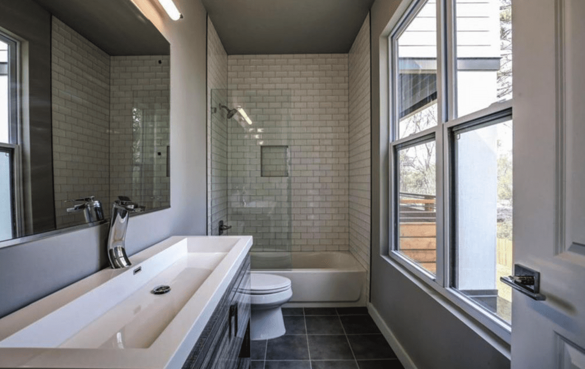 A bathroom with a sink, toilet and window.