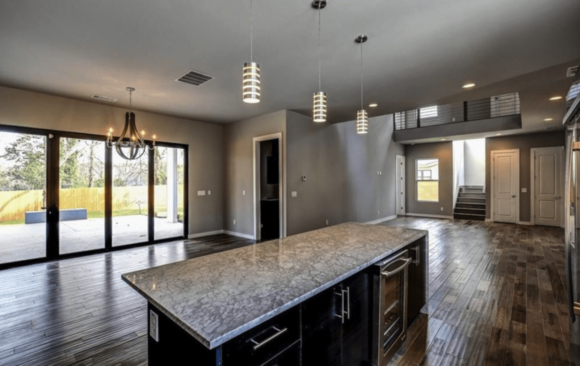 An open kitchen with hardwood floors and sliding glass doors.