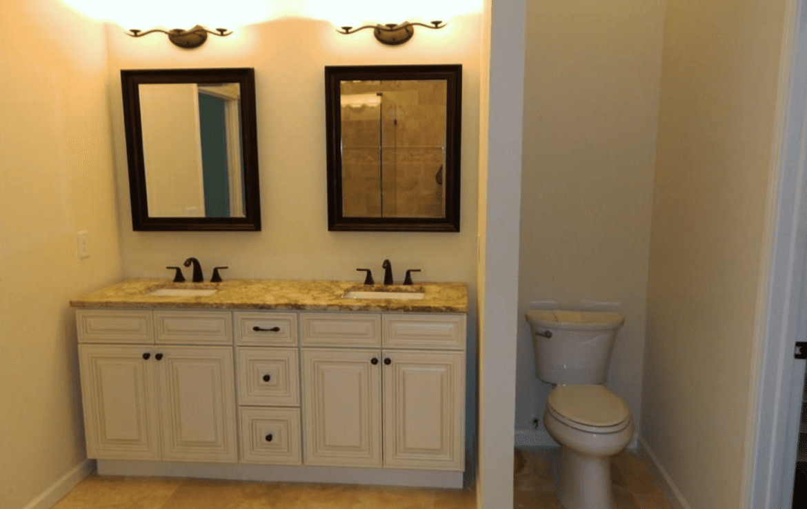 A bathroom with two sinks and a toilet.
