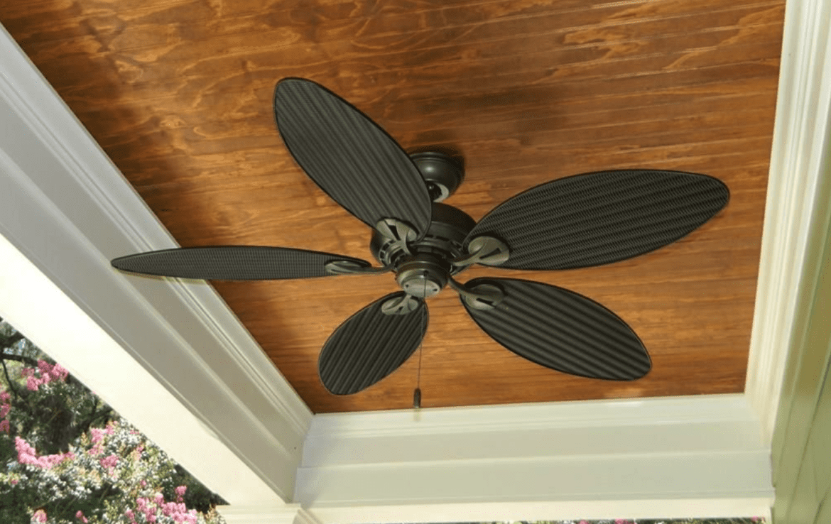 A black ceiling fan on a wooden porch.