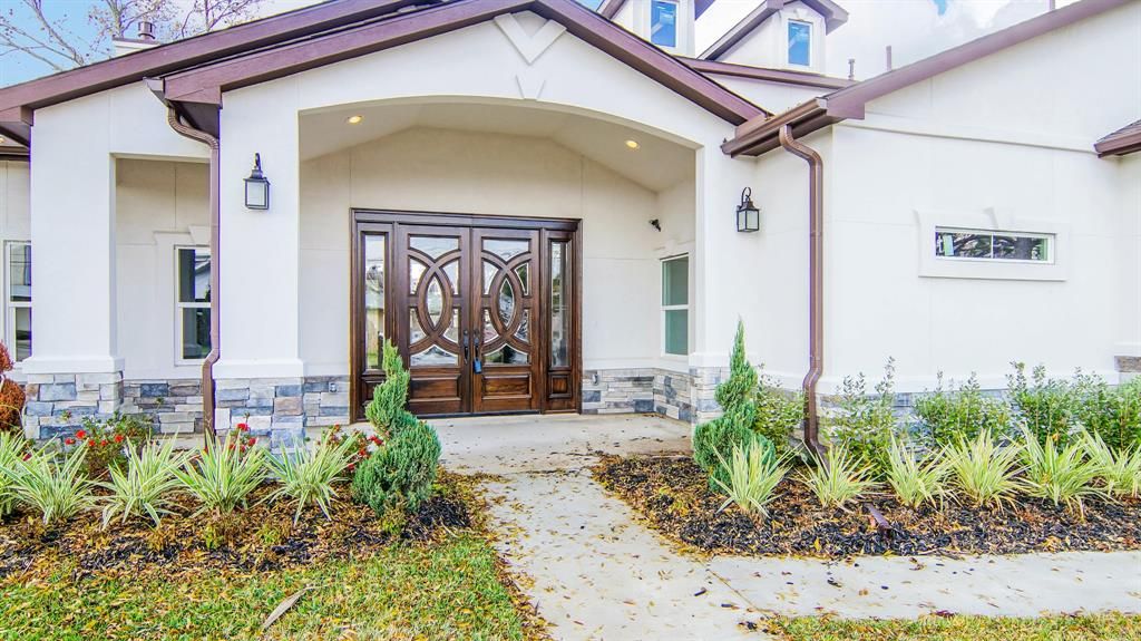 A home with a large front door and landscaping.