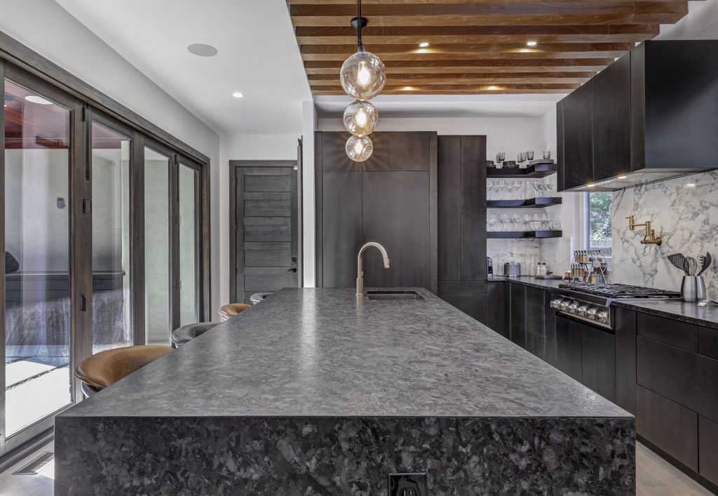 A modern kitchen with black granite counter tops.