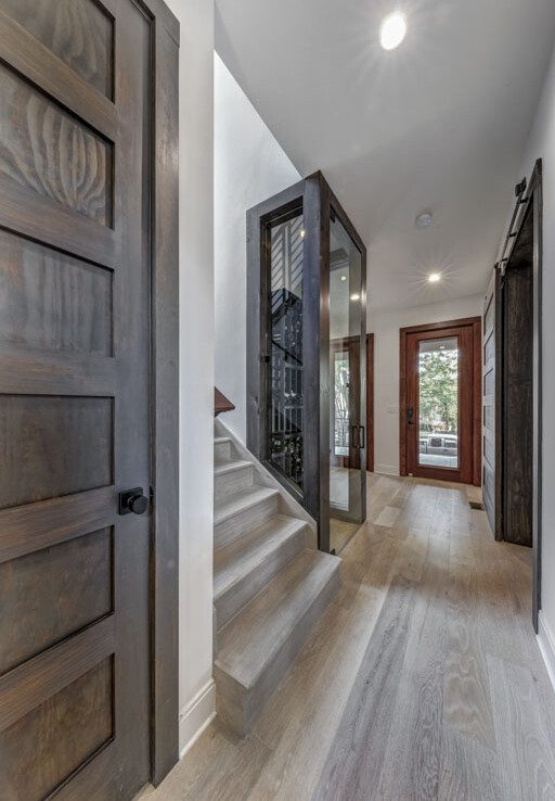 A hallway with wood floors and a glass door.