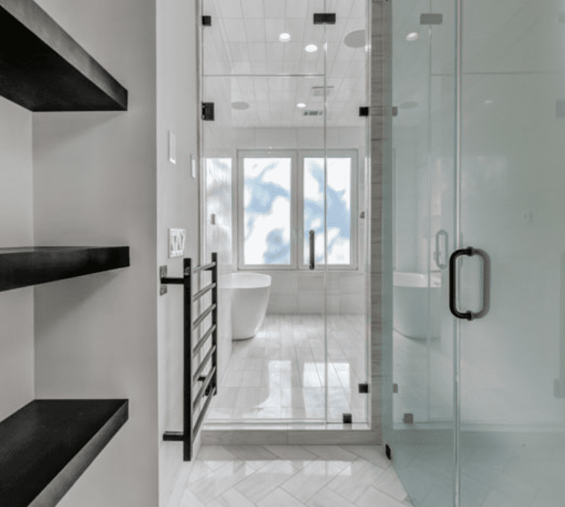A black and white bathroom with glass shelves.