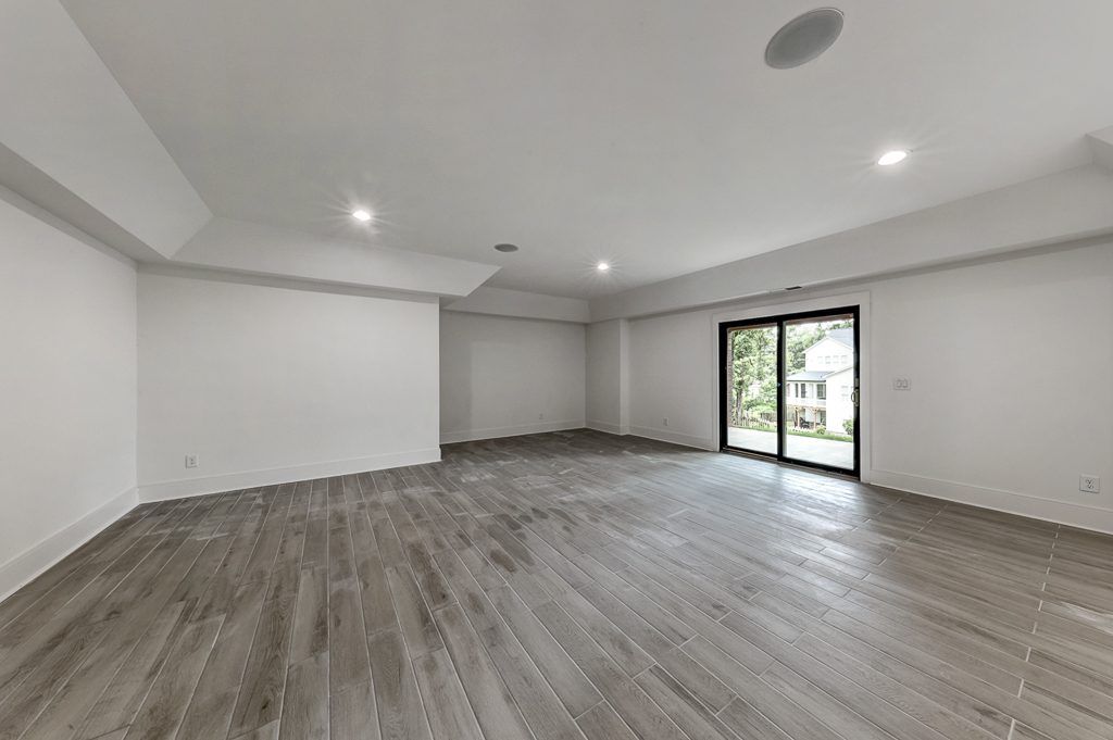 Empty living room with hardwood floors and sliding glass doors.