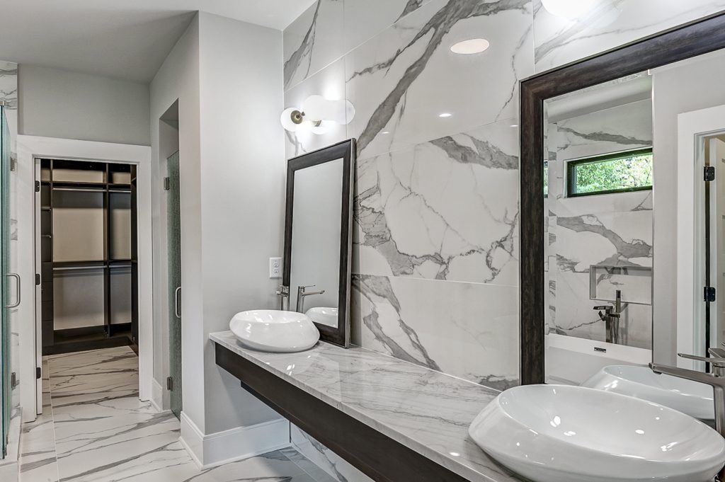 A marble bathroom with two sinks and a mirror.