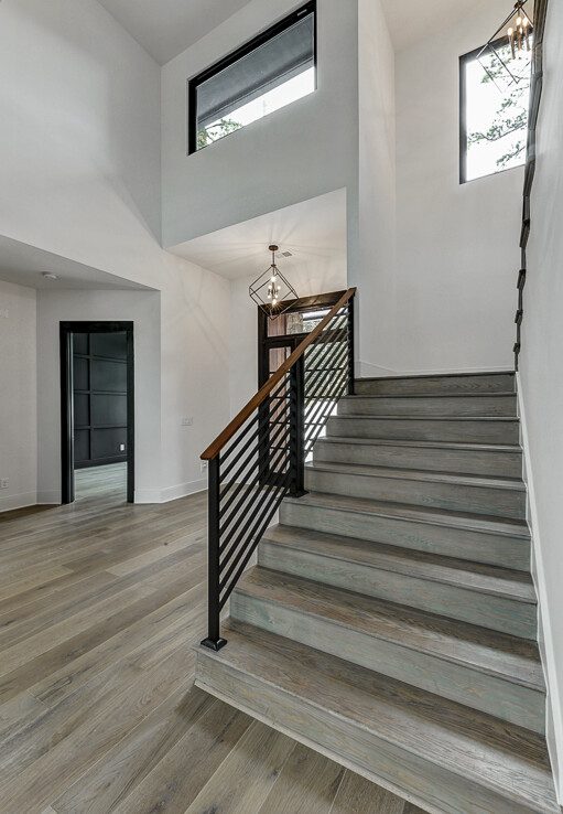 A white and wood staircase in a modern home.